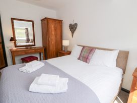 A bedroom with a double bed and wooden furniture at Cwm in Capel Curig