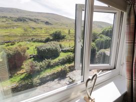 A window view of a garden and hills at Cwm in Capel Curig