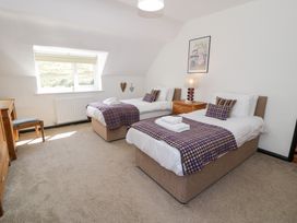 A bedroom with two beds and a desk at Cwm in Capel Curig