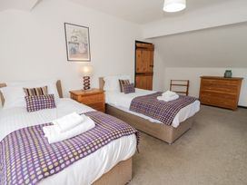 A bedroom with two beds and a chest of drawers at Cwm in Capel Curig