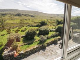 A view of mountains and garden from a window at Cwm in Capel Curig