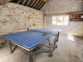 A game room with a table tennis table and a window at Cwm in Capel Curig