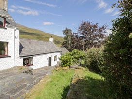 An outdoor area with a house and slate path at Cwm in Capel Curig