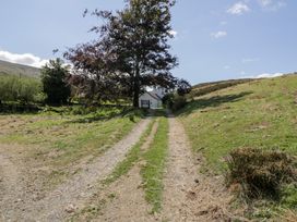 A path leading to a house with a tree along the side at Cwm in Capel Curig