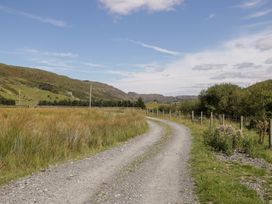 A gravel road winding through fields and hills at Cwm in Capel Curig