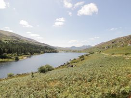 A lake surrounded by mountains and trees at Cwm in Capel Curig