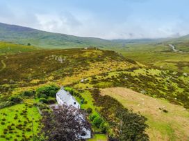 An aerial view of a house surrounded by hills and grassland at Cwm in Capel Curig