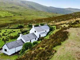 A cottage surrounded by grass and hills at Cwm in Capel Curig