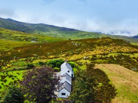 A house surrounded by trees and hills at Cwm in Capel Curig