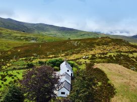 A cottage surrounded by hills and grass at Cwm in Capel Curig