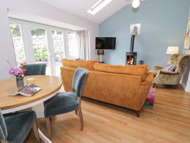 A living room with a sofa and a wood stove at Pengwern Bach Llanrwst