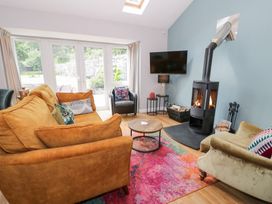 A living room with a fireplace and seating area at Pengwern Bach in Llanrwst
