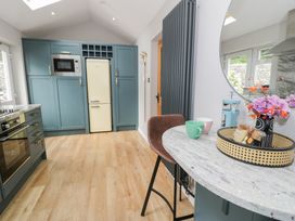 A kitchen with appliances and a small dining table at Pengwern Bach Llanrwst