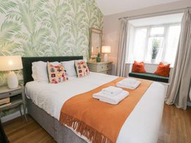 A bedroom with a bed and decorative pillows at Pengwern Bach Llanrwst