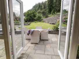 An outdoor seating area with a table and chairs at Pengwern Bach in Llanrwst