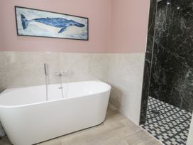 A bathtub and shower in a bathroom at Pengwern Bach in Llanrwst