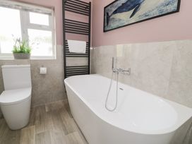 A bathroom with a bathtub and toilet at Pengwern Bach in Llanrwst