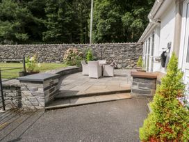 An outdoor area with paving stones and garden chairs at Pengwern Bach in Llanrwst
