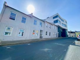 A street with white and modern buildings under a clear sky at Sea Nest in Torquay