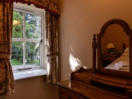 A bedroom with a window and dressing table at Fern Cottage in Akeld near Wooler