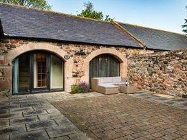An outdoor seating area with a couch and coffee table at Lupin Cottage in Akeld near Wooler