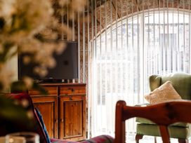 A living room with a television and a wooden cabinet at Lupin Cottage Akeld near Wooler