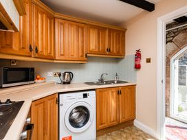 A kitchen with appliances and wooden cabinets at Lupin Cottage in Akeld near Wooler
