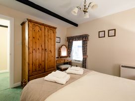 A bedroom with a wardrobe and dressing table at Lupin Cottage in Akeld near Wooler
