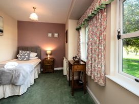 A bedroom with a bed and a nightstand at Lupin Cottage in Akeld near Wooler