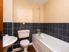 A bathroom with a toilet, bathtub, and sink at Lupin Cottage Akeld near Wooler