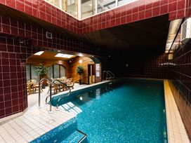 A pool area with a swimming pool and dining table at Lupin Cottage in Akeld near Wooler
