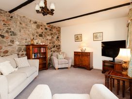 A living room with a sofa and TV at Bramble Cottage in Akeld near Wooler