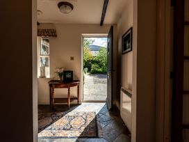 A hallway with a table and flowers at Bramble Cottage Akeld near Wooler