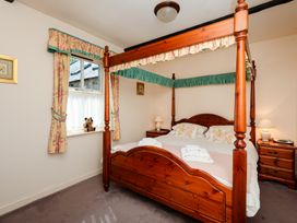 A bedroom with a four-poster bed and a bedside table at Bramble Cottage Akeld near Wooler