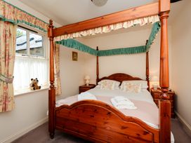 A bedroom with a four-poster bed and window at Bramble Cottage Akeld near Wooler