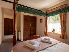 A bedroom with a four-poster bed and towels on the bed at Bramble Cottage Akeld near Wooler