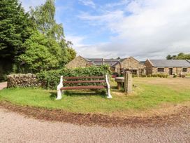 A bench and a stone wall in front of buildings at Tile Rouge in Wooler