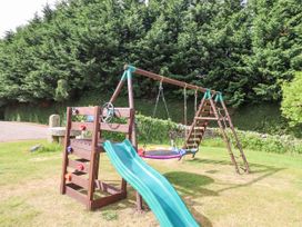 A play structure with a slide and swings at The Columbine in Akeld near Wooler