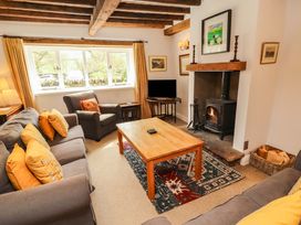 A living room with a sofa, coffee table, and fireplace at Two Town End in Mungrisdale, Mosedale