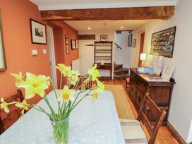 A dining room with a table and flowers at Two Town End in Mungrisdale, Mosedale