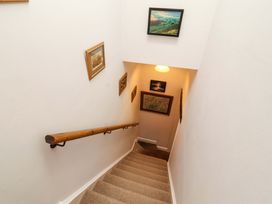 A staircase with a handrail and framed pictures at Two Town End in Mungrisdale, Mosedale