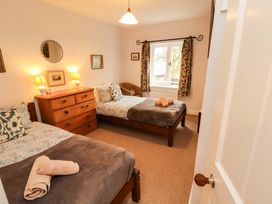 A bedroom with two beds and a dressing table at Two Town End Mungrisdale, Mosedale