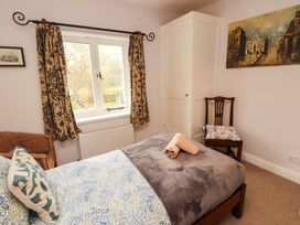 A bedroom with a bed and chair at Two Town End in Mungrisdale, Mosedale