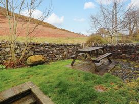 A garden with a picnic table and stone wall at Two Town End in Mungrisdale, Mosedale
