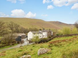 A view of houses and a hill at Two Town End in Mungrisdale, Mosedale