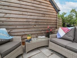 An outdoor seating area with a sofa and a table at The Stable House in Sherborne