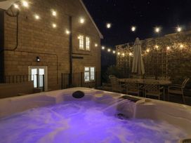 An outdoor area with a hot tub and patio furniture at The Stable House in Sherborne