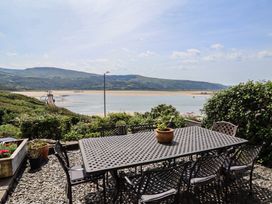 An outdoor area with a table and chairs overlooking a river at 5 Porkington Terrace in Barmouth