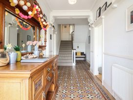 A hallway with a staircase and console table at 5 Porkington Terrace in Barmouth