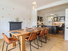 A dining room with a table and chairs adjoining a kitchen at 5 Porkington Terrace in Barmouth